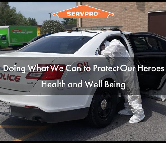 SERVPRO Technician with Tyvex Suit Wiping down Police Unit with Hospital Grade Disinfectant